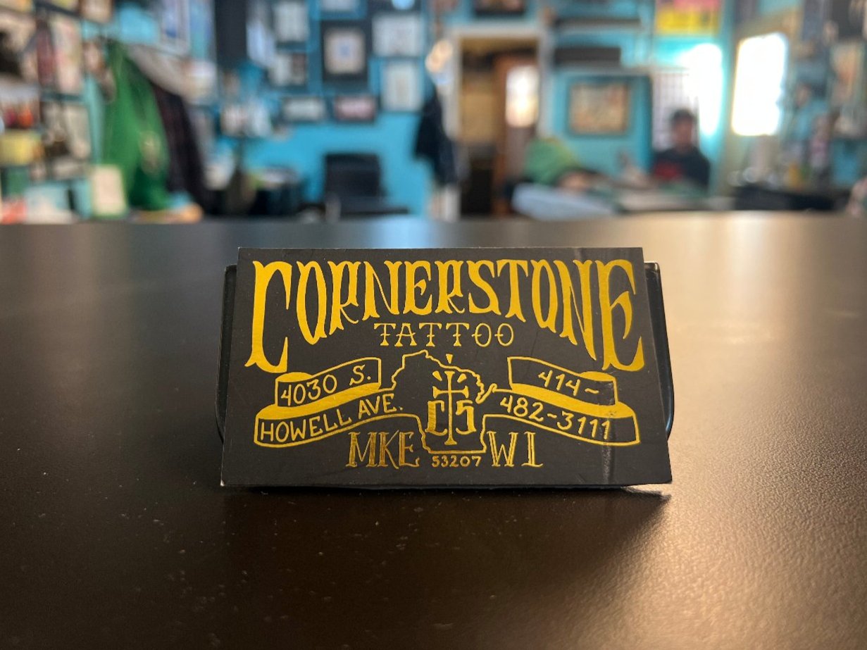 Cornerstone Tattoo business card sitting on tattoo shop counter