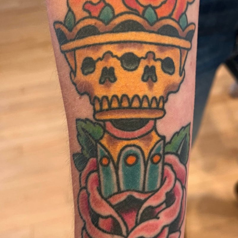 Julio Avila tattoo of a flaming torch inside a rose on a forearm